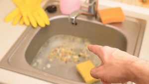 sink clogged with food scraps filled with water